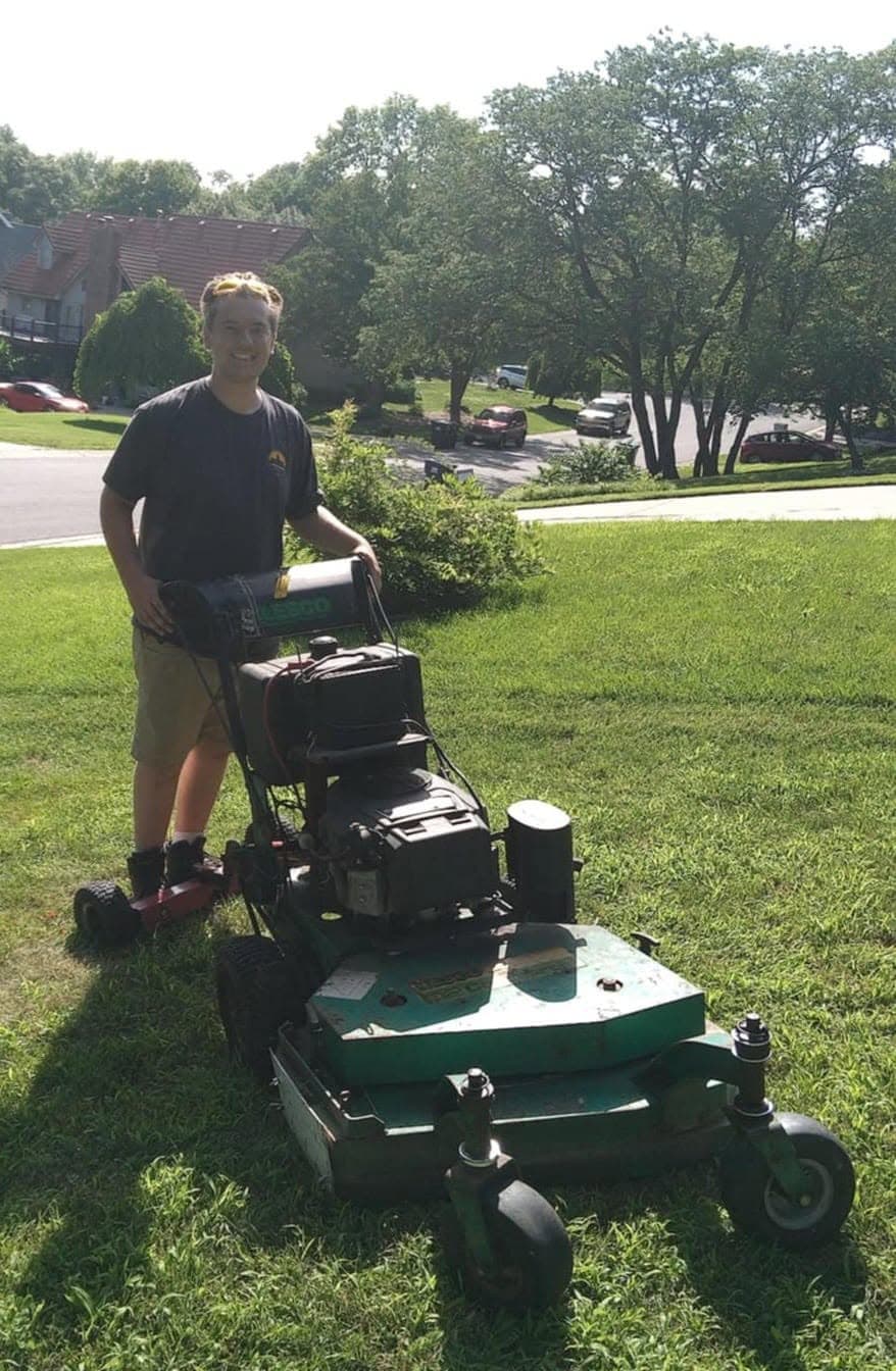Isaac mowing a lawn